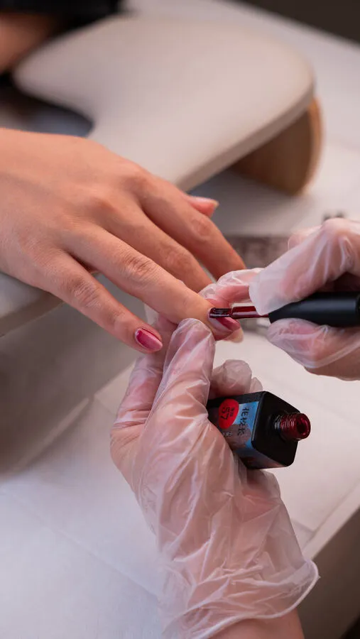 Pink gel polish applied during a manicure